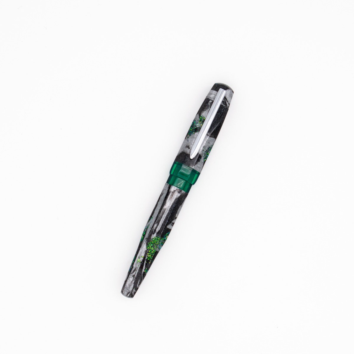 A fountain pen with a shimmer black, silver, and green marble patterned barrel with translucent green accents and a silver clip, shown diagonally on a plain white background.