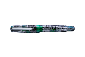 A fountain pen with a shimmer black, silver, and green marble patterned barrel with translucent green accents and a silver clip, shown diagonally on a plain white background.