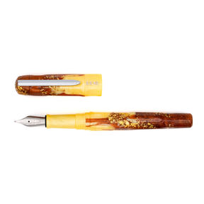 An uncapped fountain pen with yellow and amber marble and gold flake accents with a silver nib and clip. The BENU logo is engraved with silver under the clip. The pen is photographed on a clean white background.