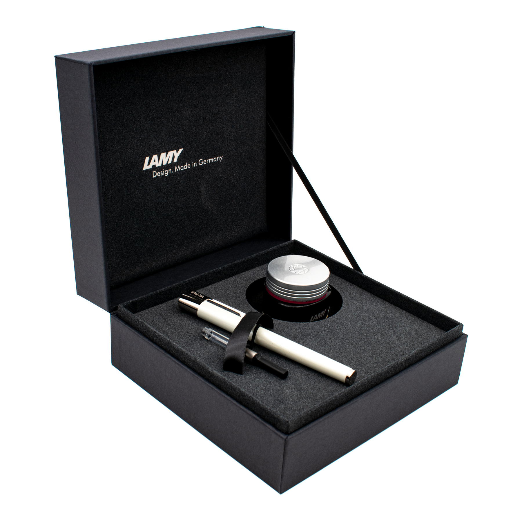 A luxury pen gift set presented in an open black box with a gray foam insert. The set includes a white and silver pen, a clear and black cartridge, a black ribbon, and a silver-lidded ink jar.