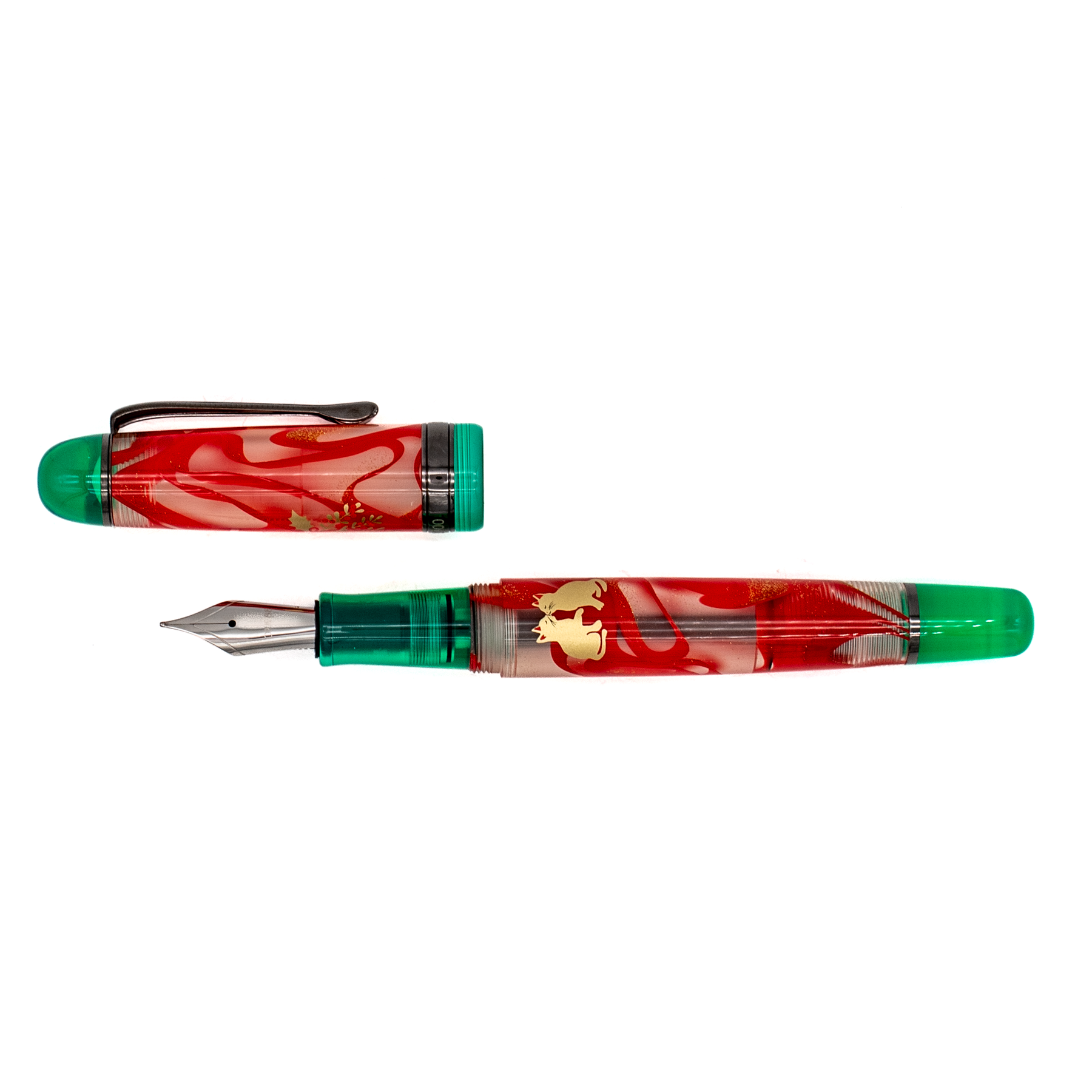 A red and green translucent fountain pen with its black trimmed cap parallel to the nib with gold decorative details and a silver nib, shown diagonally on a plain white background.