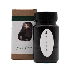 A bottle of Organics Studio 'James Joyce Hunter Green' in front of its brown box with a white and dark green label with a vintage portrait on a white background.