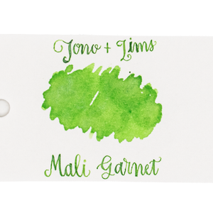 An ink swatch in lime green on white paper, with the text 'Tono+Lims' at the top and 'Mali Garnet' at the bottom in matching green script on a plain white background.